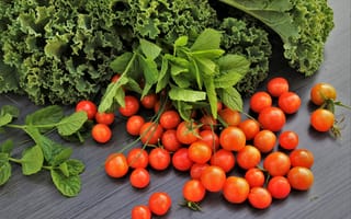Картинка Красные мелкие помидоры на столе с зеленью