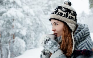 Картинка Красивая девушка в теплой шапке пьет кофе зимой на улице