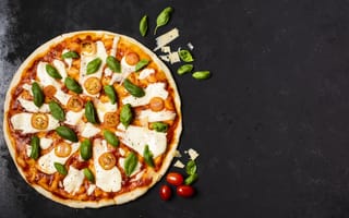 Картинка Пицца с сыром, базиликом и помидорами на черном столе