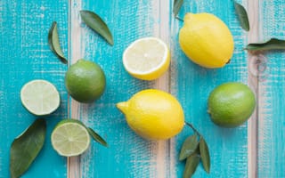 Картинка Желтые лимоны и зеленые плоды лайма на столе