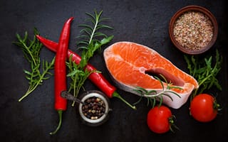 Картинка Кусок свежей красной рыбы на столе со специями, красным перцем и помидорами