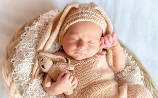 Картинка Спящий грудной ребенок в вязаном костюме