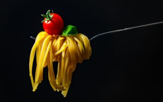 Картинка Спагетти с помидором на вилке на черном фоне