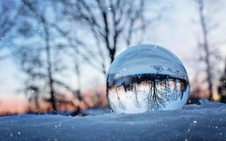 Картинка Большой стеклянный шар лежит на холодном снегу