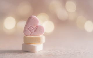 Картинка Маленькие конфеты в форме сердца на розовом фоне
