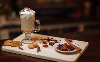 Картинка Горячее какао со сливками на столе с печеньем, зернами кофе и пряностями