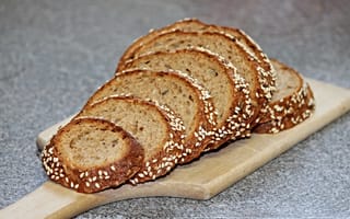 Обои Свежий хлеб нарезан на доске на столе