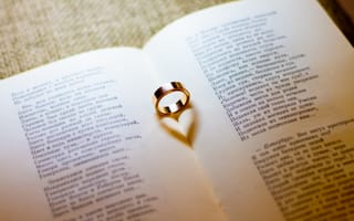 Картинка Золотое обручальное кольцо лежит на открытой книге