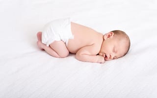 Обои Маленький грудной ребенок в памперсе спит на белом фоне
