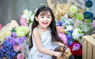Картинка Улыбающаяся маленькая девочка азиатка на лошадке