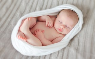 Картинка Новорожденный беззащитный ребенок спит в белой колыбели