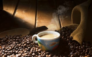 Картинка Чашка горячего кофе стоит на зернах