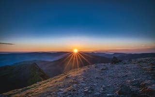 Картинка Рассвет яркого солнца в голубом небе над горами