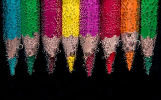 Обои Разноцветные карандаши в воде на черном фоне