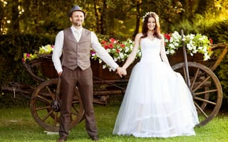 Обои Жених и невеста на фоне телеги цветов