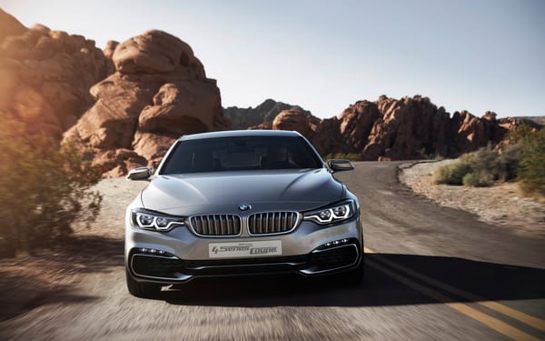 Обои Серебристый автомобиль BMW 4 Series Coupe на дороге у скал