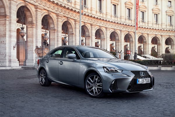 Обои Стильный серебристый Lexus IS на фоне здания