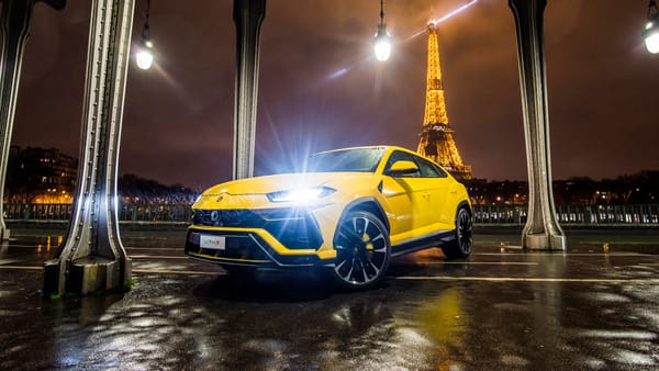 Обои Желтый Lamborghini Urus,2018 с включенными фарами на фоне Эйфелевой башни