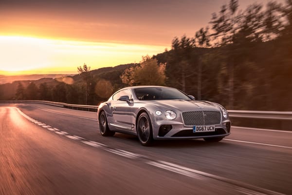 Обои Серебристый автомобиль Bentley Continental GT 2018 года на фоне заката
