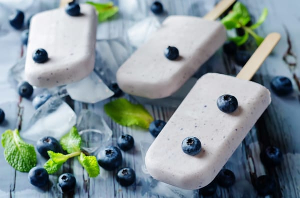 Обои Вкусное мороженое с ягодами черники на столе с кусочками льда