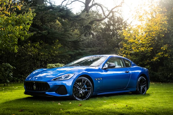 Обои Синий автомобиль Maserati GranTurismo на фоне деревьев