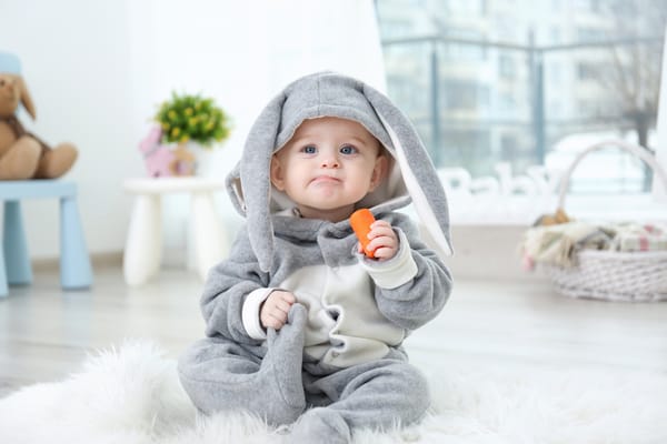 Обои Маленький мальчик в костюме зайчика с морковкой в руке